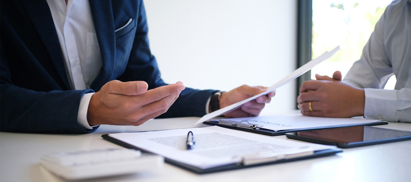 Cut off shot of two male business employees discussing a contract 