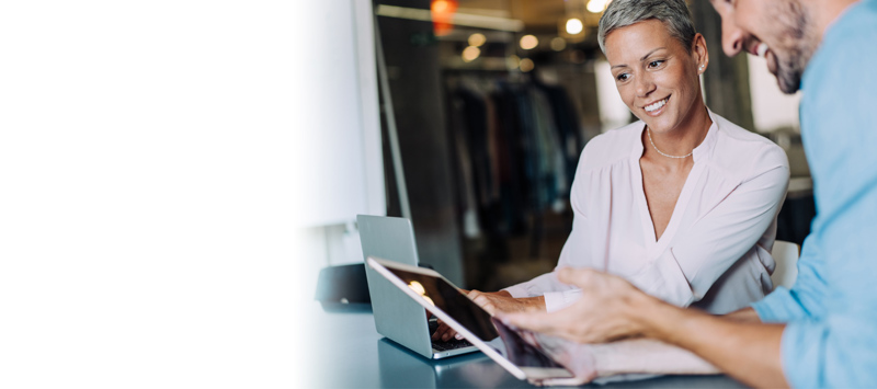 Woman with short hair in a pink blouse looking at a computer screen